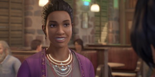 Screenshot of a smiling Charlotte Harmon in The Black Lantern. She is wearing multiple necklaces and a purple cardigan. Her hair is tied up into a bun, with loose strands hanging in front of her ears.