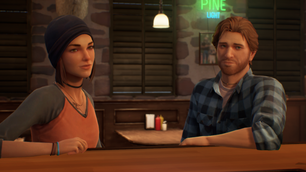 Screenshot of Steph Gingrich and Ryan Lucan in The Black Lantern. Both of them are resting an arm onto the bar they are sitting at. Ryan is wearing a blue-purple checkered flannel, Steph is wearing a black beanie and a red shirt with black sleeves.